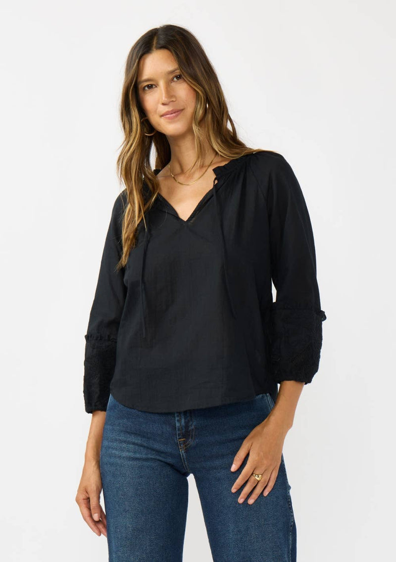 Black frilled sleeve split neck blouse features a relaxed fit and intricate detailing, perfect for Long Island boutique fashion enthusiasts.