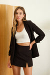 Tailored black 3/4 ruched sleeve blazer paired with a white crop top and mini skirt, perfect for chic Long Island boutique fashion.