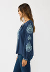 Navy embroidered raglan blouse features intricate floral designs, a relaxed fit, and button closure, perfect for Long Island boutique fashion.