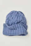 Soft light blue cable-knit beanie with a rolled ribbed brim, perfect for cool days in Long Island boutique fashion.