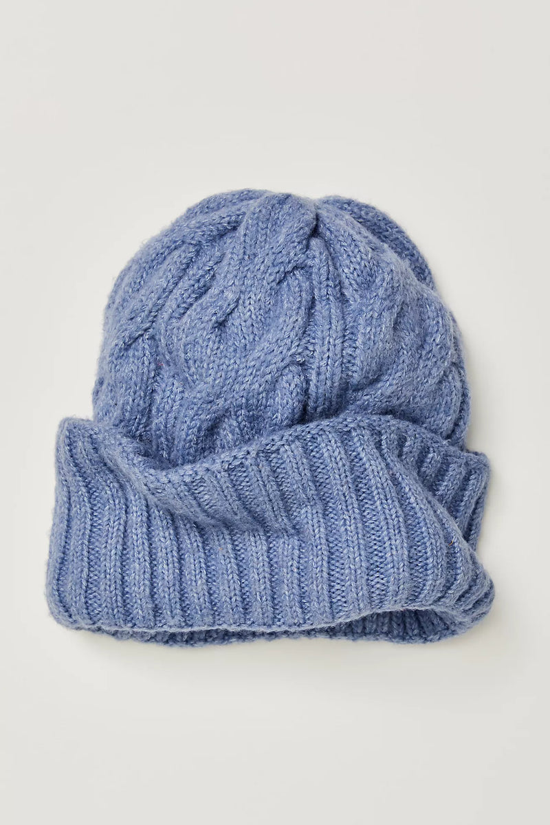 Soft light blue cable-knit beanie with a rolled ribbed brim, perfect for cool days in Long Island boutique fashion.