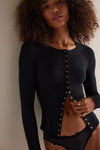 Model wearing Free People Going Places Cardi Top in black — slim thermal knit with snap-front closure, available at TandyWear Boutique in Commack, NY. front view black