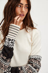 Cozy cream long-sleeve top featuring unique patterned cuffs with black stripes and vibrant prints, perfect for Long Island boutique fashion.