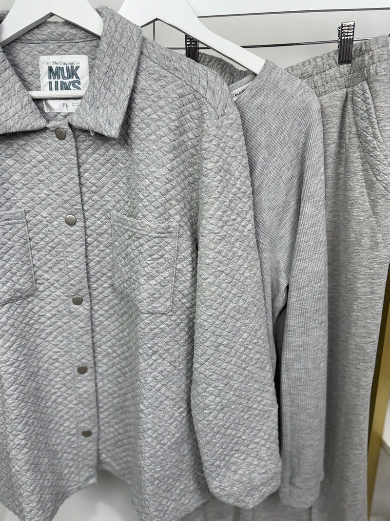 Gray textured shirt and pants on hangers with a visible brand label.