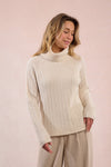 Cozy cream cable knit turtleneck sweater with long sleeves and a relaxed fit, perfect for chilly days in Long Island boutique fashion.