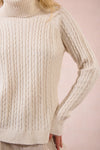 Cozy cable knit turtleneck sweater in soft cream, featuring ribbed detailing and a relaxed fit, perfect for Long Island boutique fashion.