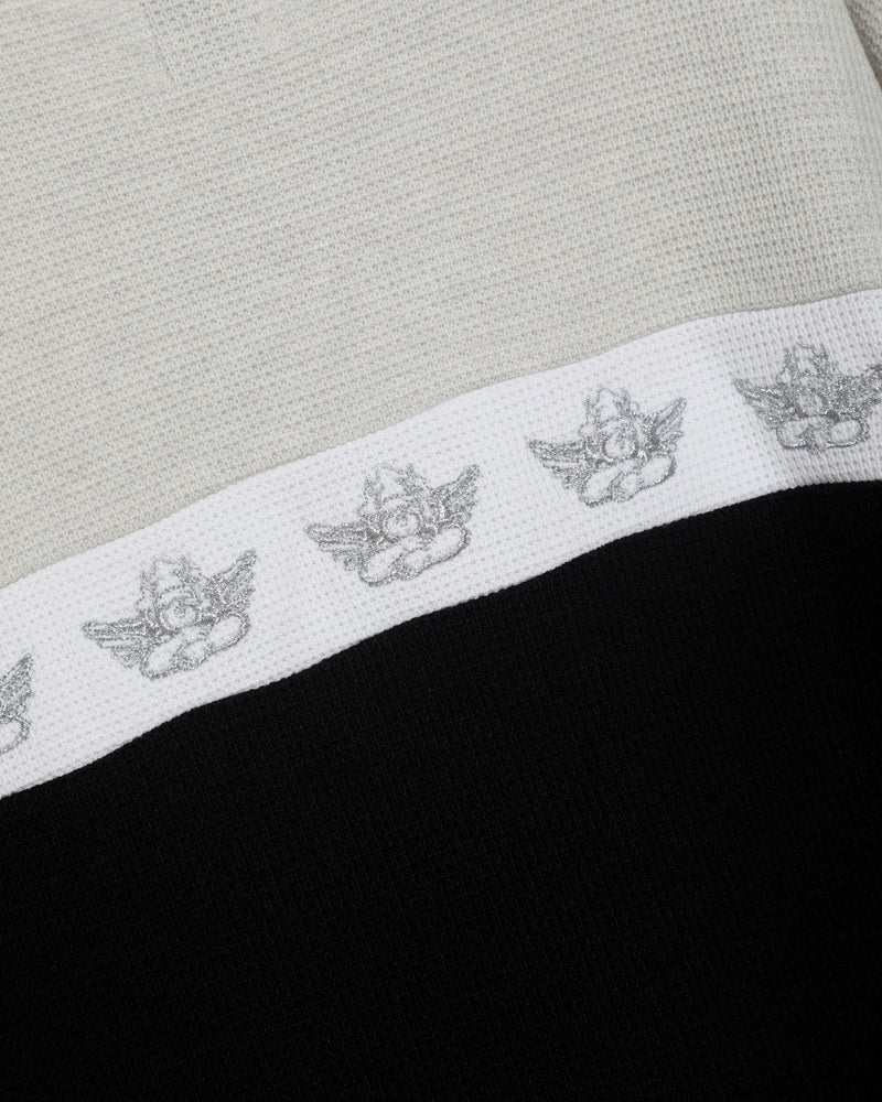 High-class crewneck in cream and black with subtle winged logo detailing, perfect for trendy Long Island boutique fashion.