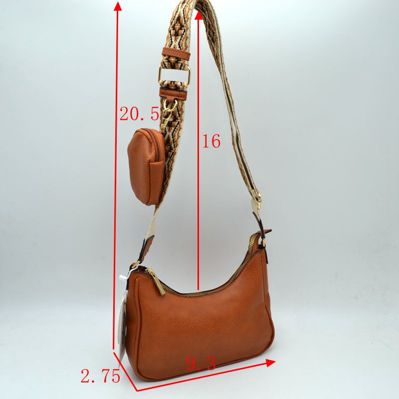 Stylish tan crossbody bag with a textured finish and colorful guitar strap, perfect for Long Island boutique fashion enthusiasts.