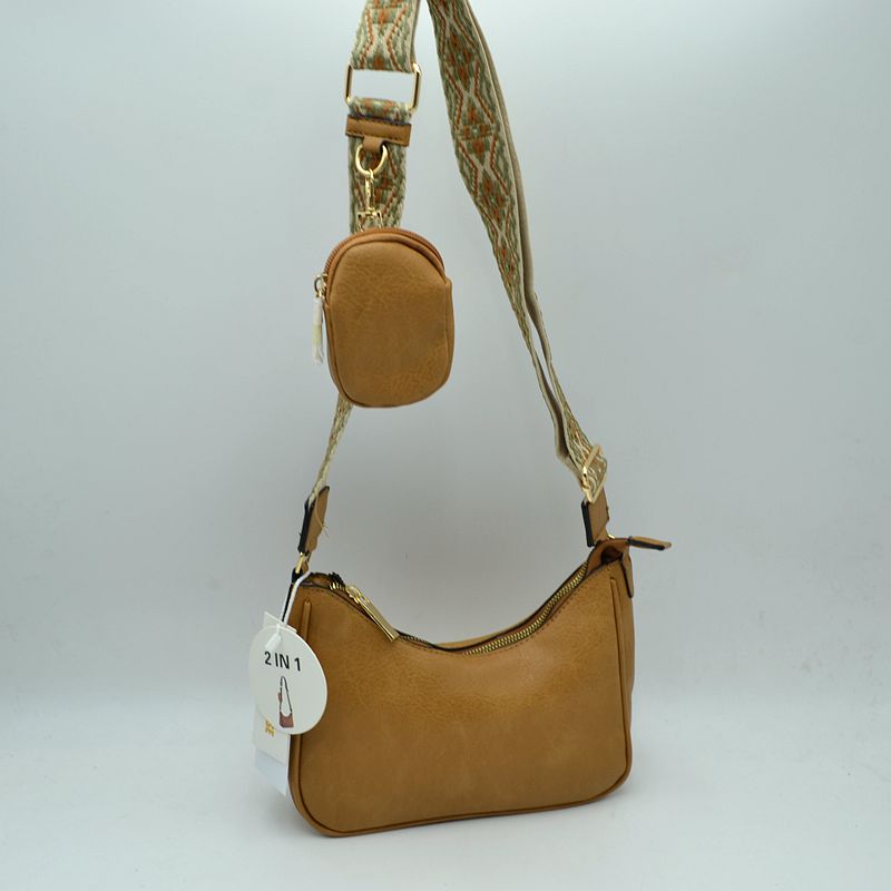 Stylish tan crossbody bag with a textured finish and colorful guitar strap, perfect for Long Island boutique fashion enthusiasts.