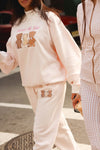 Cozy blush joggers featuring an adorable teddy bear graphic, perfect for casual wear at a Long Island fashion boutique.