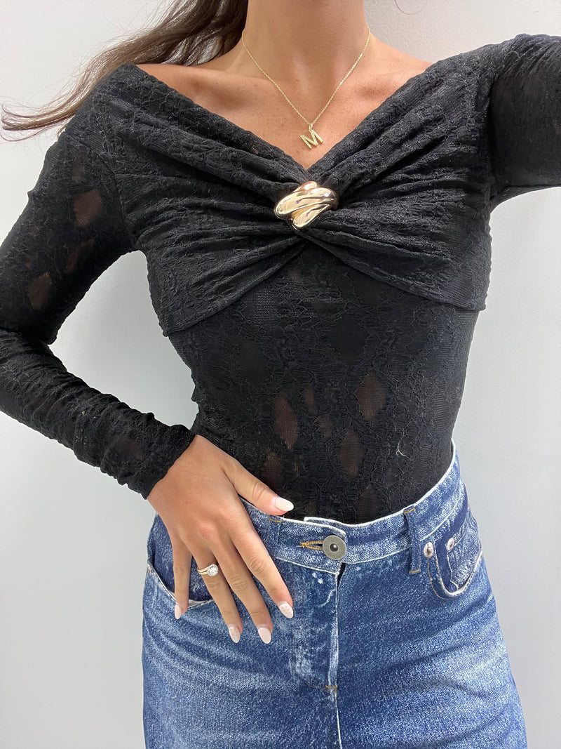 Elegant black lace knit top featuring a gathered neckline and an ornate silver brooch, perfect for Long Island boutique fashion.