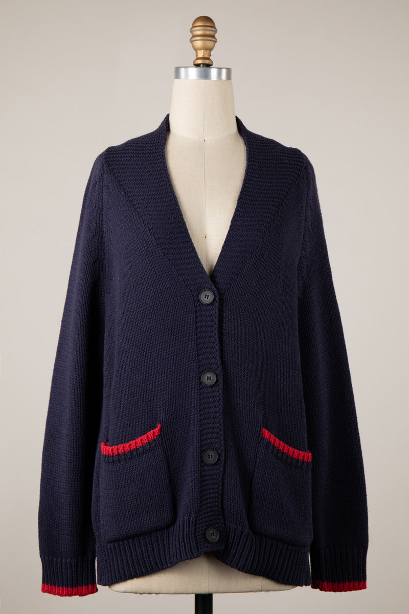 Navy duotone cardigan featuring a button-down front, deep V-neck, and contrasting red pocket trims, perfect for Long Island boutique fashion.