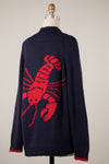 Navy cardigan featuring a vibrant red lobster design on the back, ideal for a playful touch in Long Island boutique fashion.