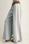 Wide-leg color block denim drawstring pants in soft blue and white, perfect for casual looks at a Long Island women's boutique.