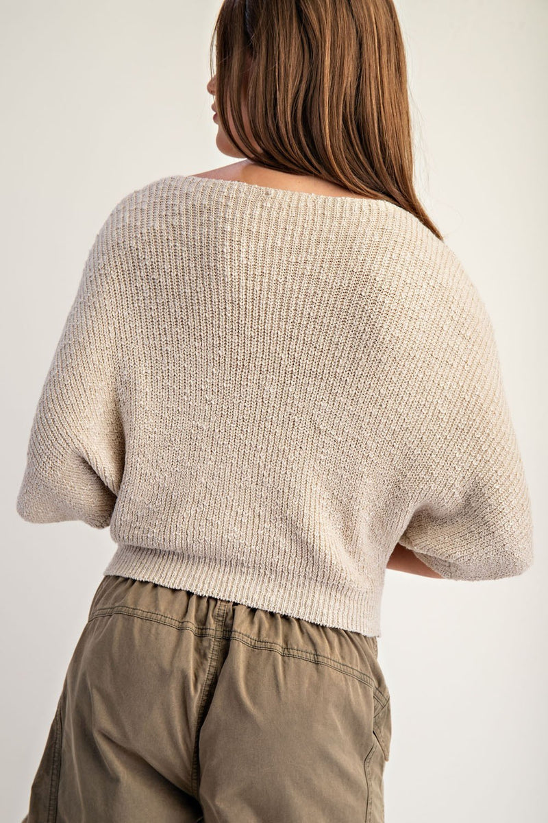 Cropped knit sweater in soft beige features half dolman sleeves and a relaxed fit, ideal for contemporary Long Island boutique fashion.