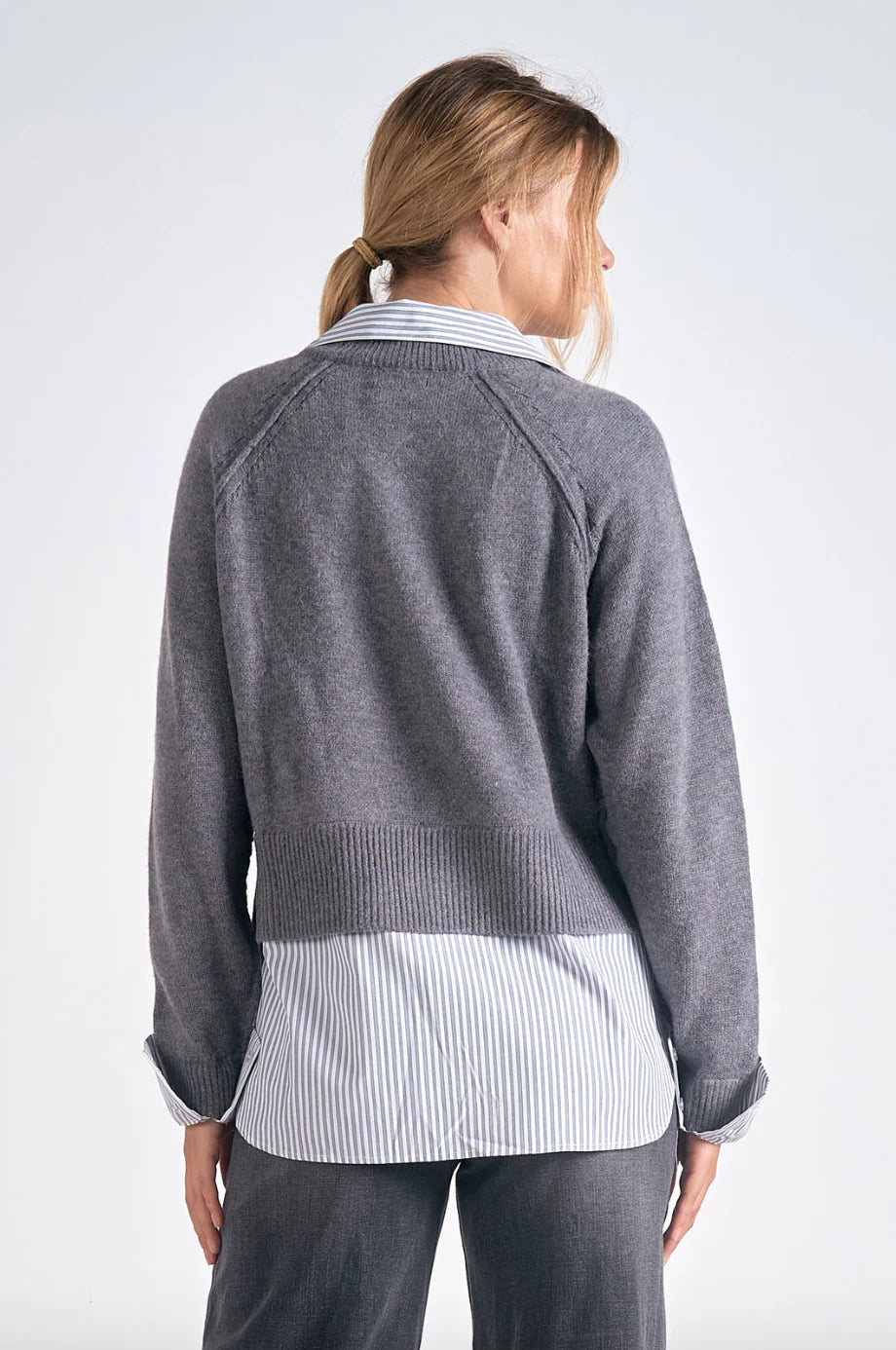 Cozy gray long sleeve sweater with a v-neck and a striped shirt layer, blending comfort and style for trendy Long Island boutique fashion.