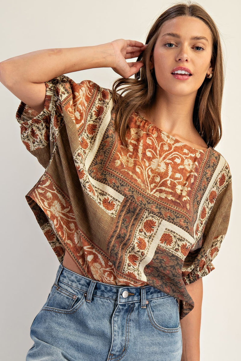 Boxy dolman sleeve top in warm earthy tones, featuring intricate floral patterns, perfect for Long Island boutique fashion styling.