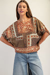 Boxy dolman sleeve top featuring intricate floral patterns in warm earthy tones, perfect for a chic Long Island boutique fashion look.