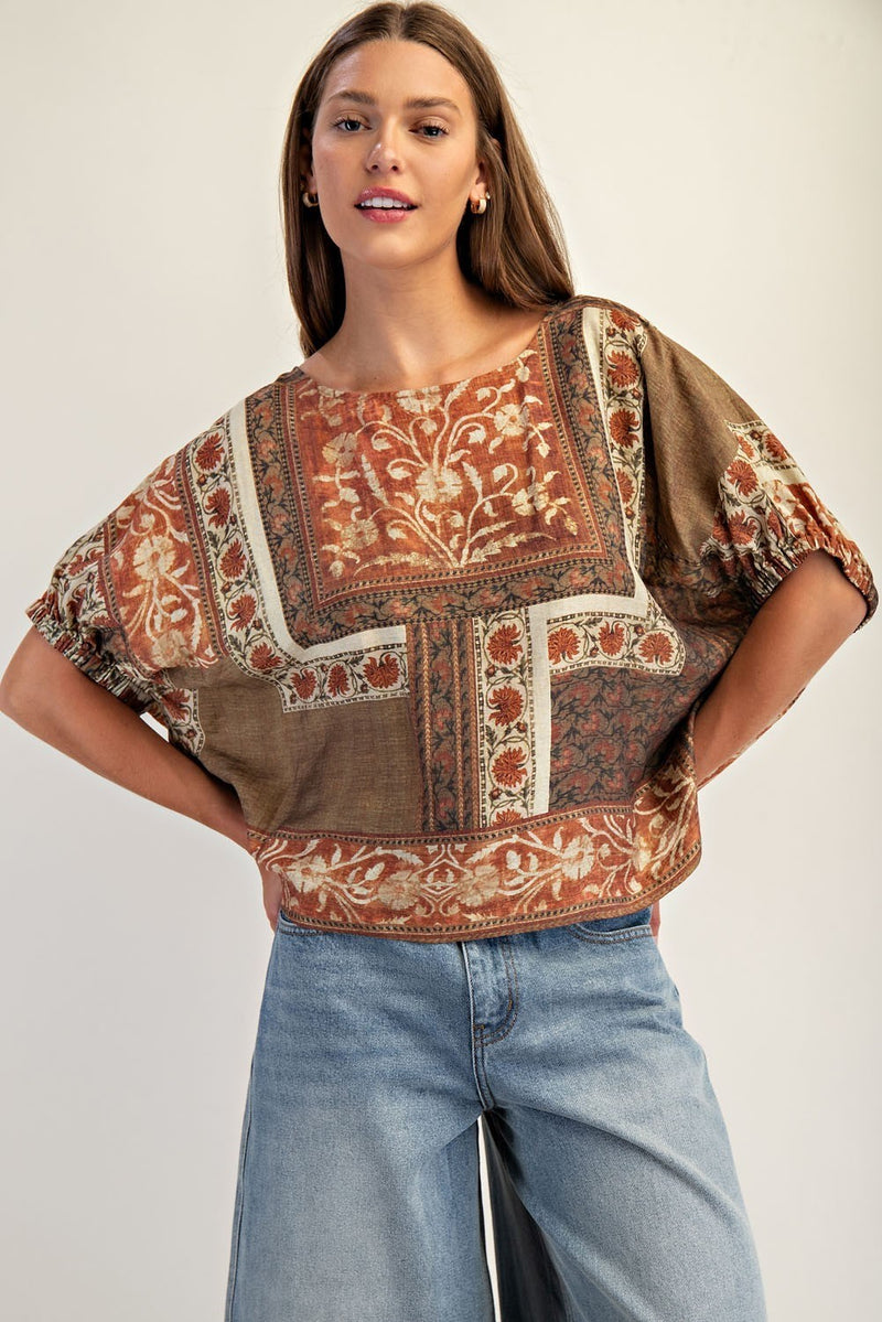 Boxy dolman sleeve top featuring intricate floral patterns in warm earthy tones, perfect for a chic Long Island boutique fashion look.