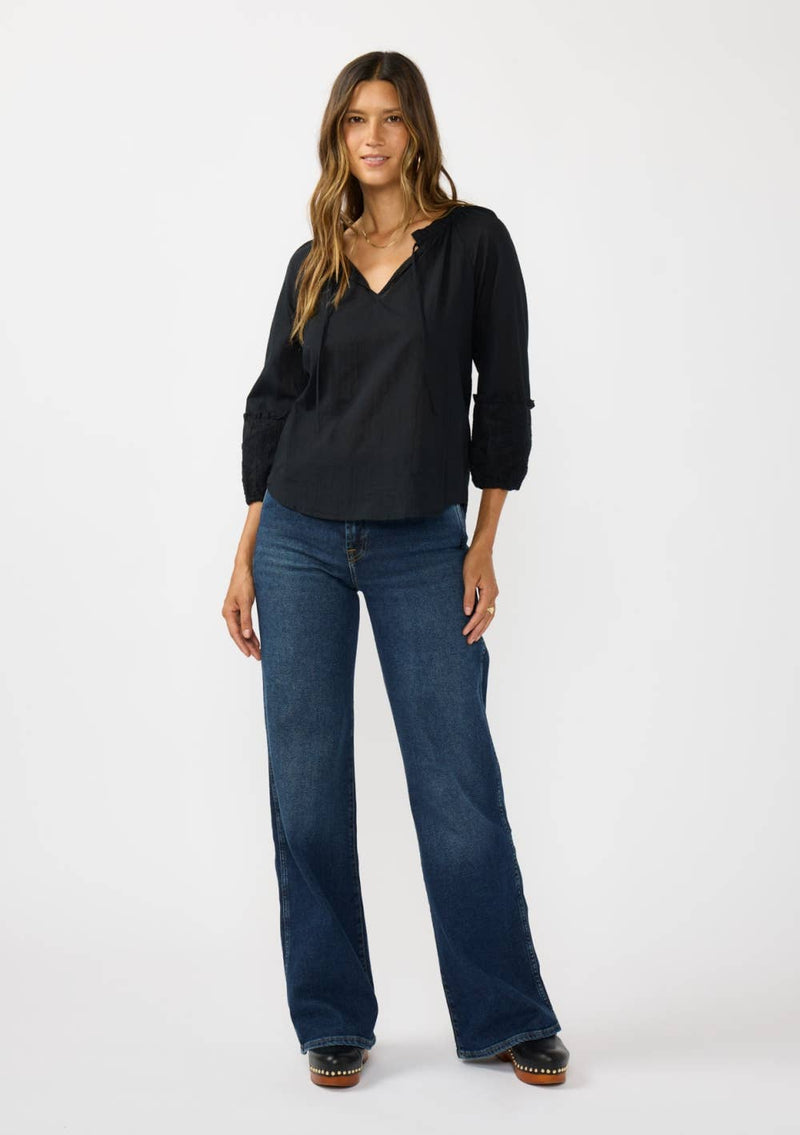 Black frilled sleeve split neck blouse featuring a relaxed fit, perfect for a stylish look in Long Island boutique fashion.
