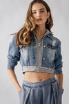 Cropped denim jacket with distressed details and zip front, featuring jersey hood and a relaxed fit, perfect for Long Island boutique fashion.