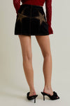 Black denim mini skirt featuring leopard print stars, showcased as a stylish piece in Long Island boutique fashion.