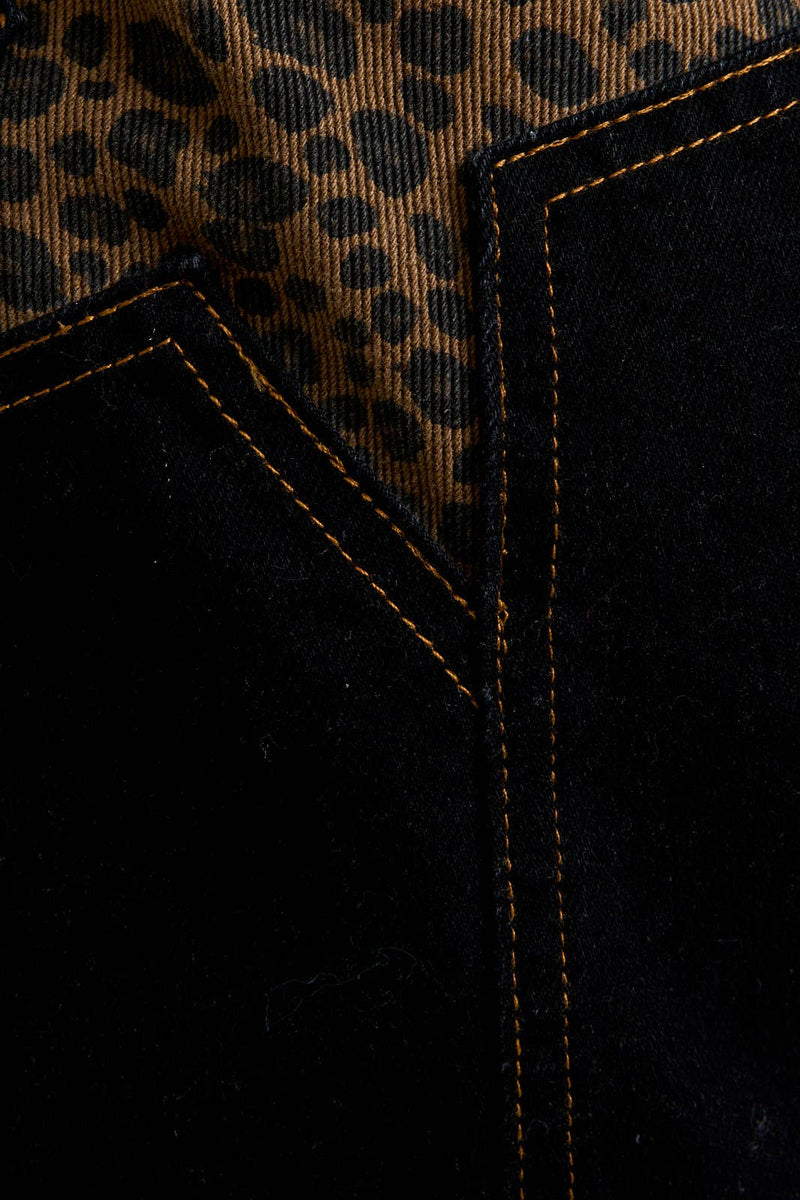 Black denim skirt featuring leopard star patterns and contrasting orange stitching, perfect for trendy Long Island boutique fashion.