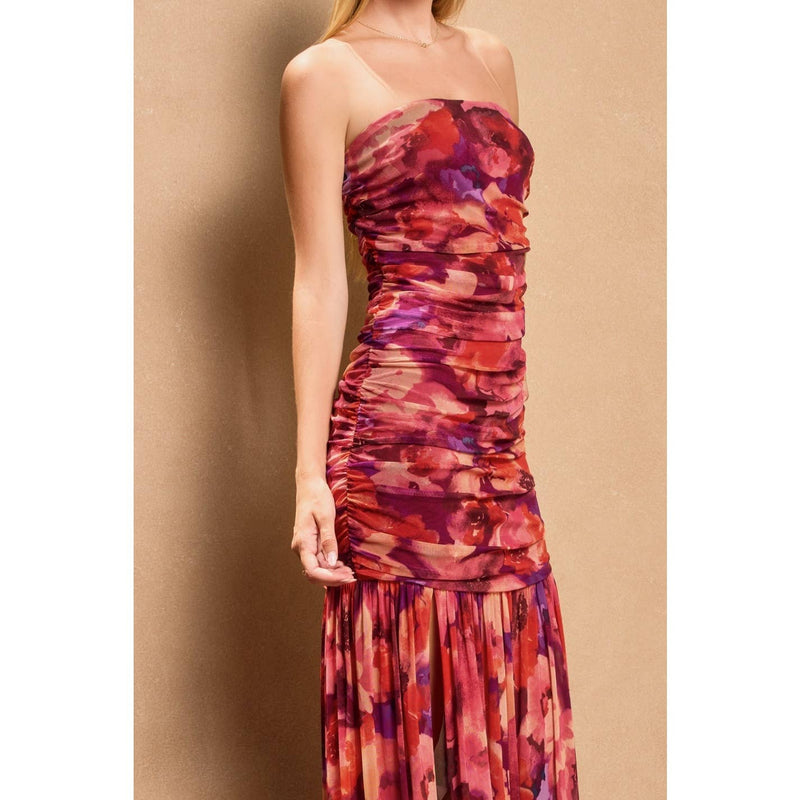 Ruched tube top dress in vibrant red and purple floral pattern, fitted bodice flowing into a pleated skirt, perfect for Long Island boutique fashion.