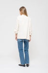 Light cream 3/4 ruched sleeve blazer, tailored fit, paired with denim, embodying chic Long Island boutique fashion.