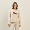 Light beige sweater featuring a playful black and brown dachshund with a red bow, ideal for cozy Long Island boutique fashion.