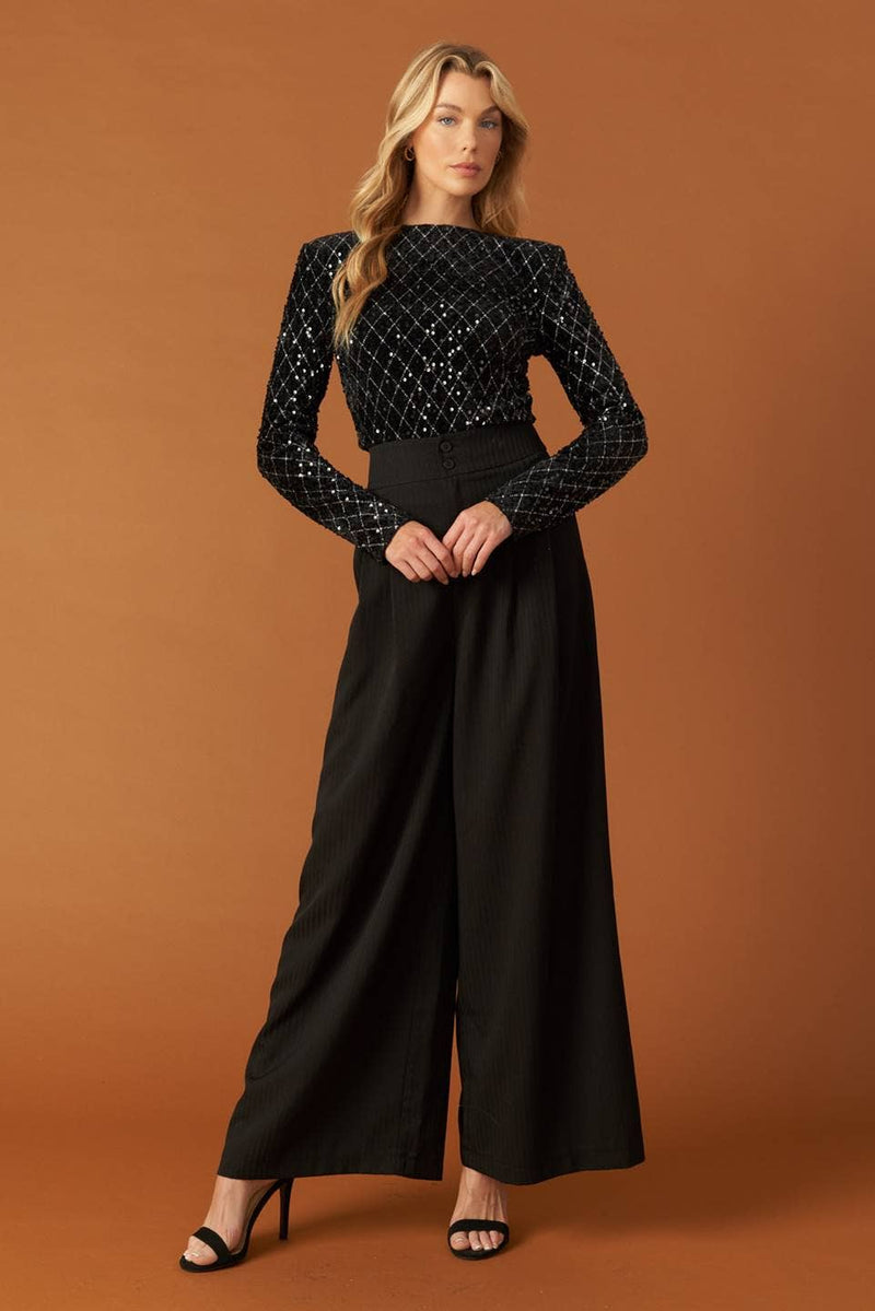 Black long-sleeve bodysuit adorned with shimmering sequins, perfectly pairing with tailored pants for a chic Long Island boutique fashion look.