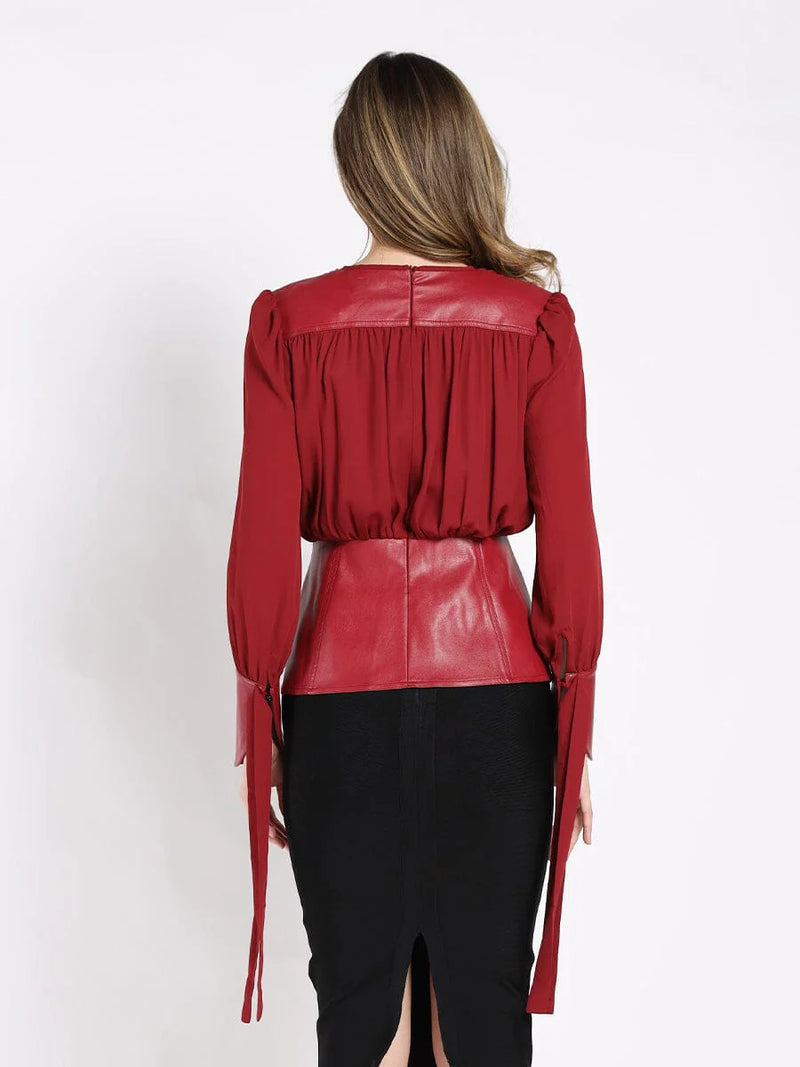 Red Gracia blouse featuring stylish leather cuffs and a flattering peplum bottom, perfect for Long Island boutique fashion enthusiasts.