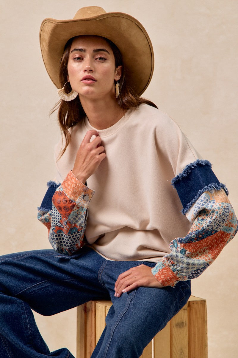 French terry top featuring printed denim sleeves with a frayed edge, perfect for a stylish look in Long Island boutique fashion.