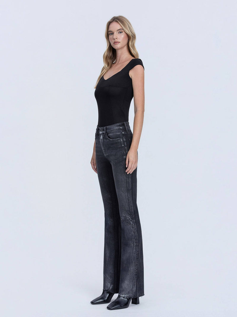 Model wearing Flying Monkey High Rise Metallic Coated Bootcut Jeans in black — metallic finish with distressed hem, available at TandyWear Boutique in Commack, NY. full front left side view 