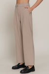 Light beige front pleated detail pants with a high-waisted fit, wide legs, and practical side pockets, perfect for Long Island boutique fashion.