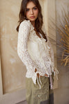 Elegant cream lace blouse featuring ruffled edges and tie details, perfect for a chic look in Long Island boutique fashion.