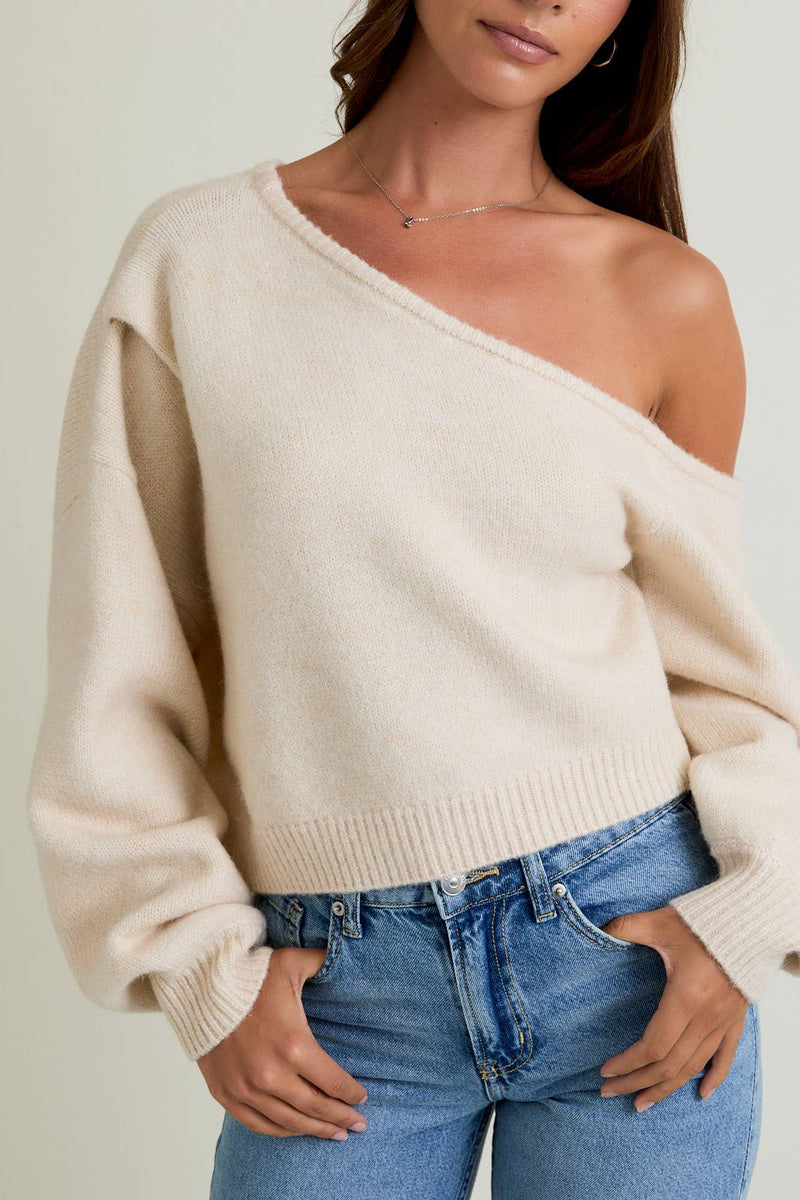 Cozy asymmetrical shoulder sweater top in soft beige, featuring a relaxed fit and ribbed hem, perfect for Long Island boutique fashion.