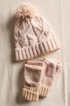 Cozy knitted hat with a pom-pom and matching fingerless gloves in soft pastel pink, perfect for Long Island boutique fashion enthusiasts.