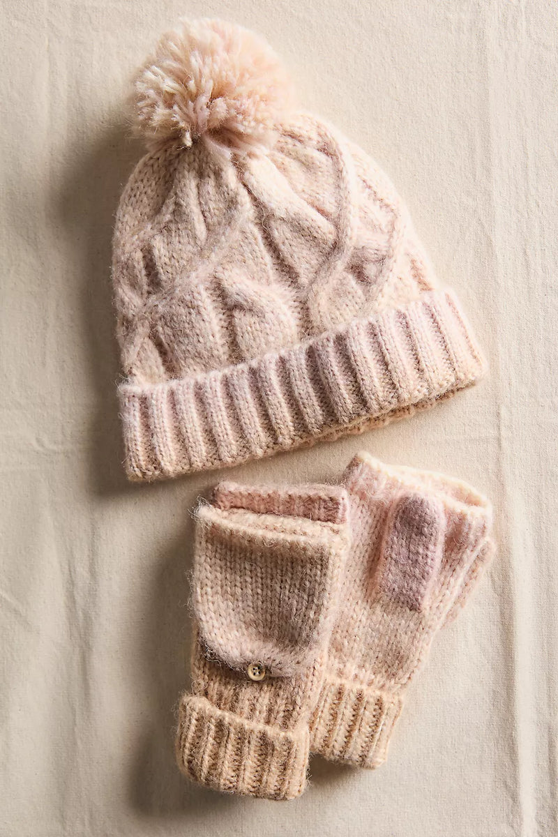 Cozy knitted hat with a pom-pom and matching fingerless gloves in soft pastel pink, perfect for Long Island boutique fashion enthusiasts.