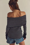 Off-the-shoulder black and white striped sweater with a fitted silhouette, perfect for Long Island boutique fashion styling.