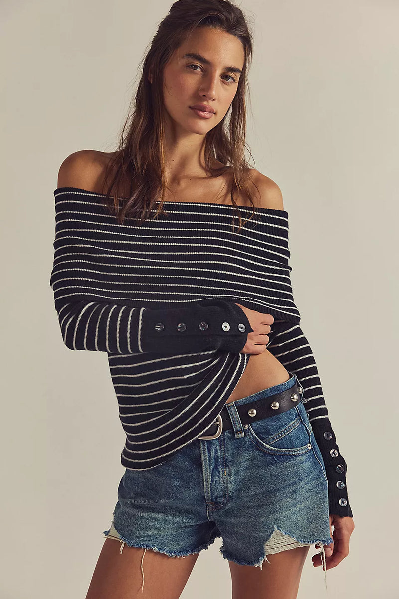Off-the-shoulder black and white striped sweater with buttoned sleeves, styled with denim shorts, perfect for Long Island boutique fashion.