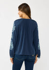 Navy blue embroidered raglan button blouse with delicate floral patterns on the sleeves, perfect for Long Island boutique fashion.