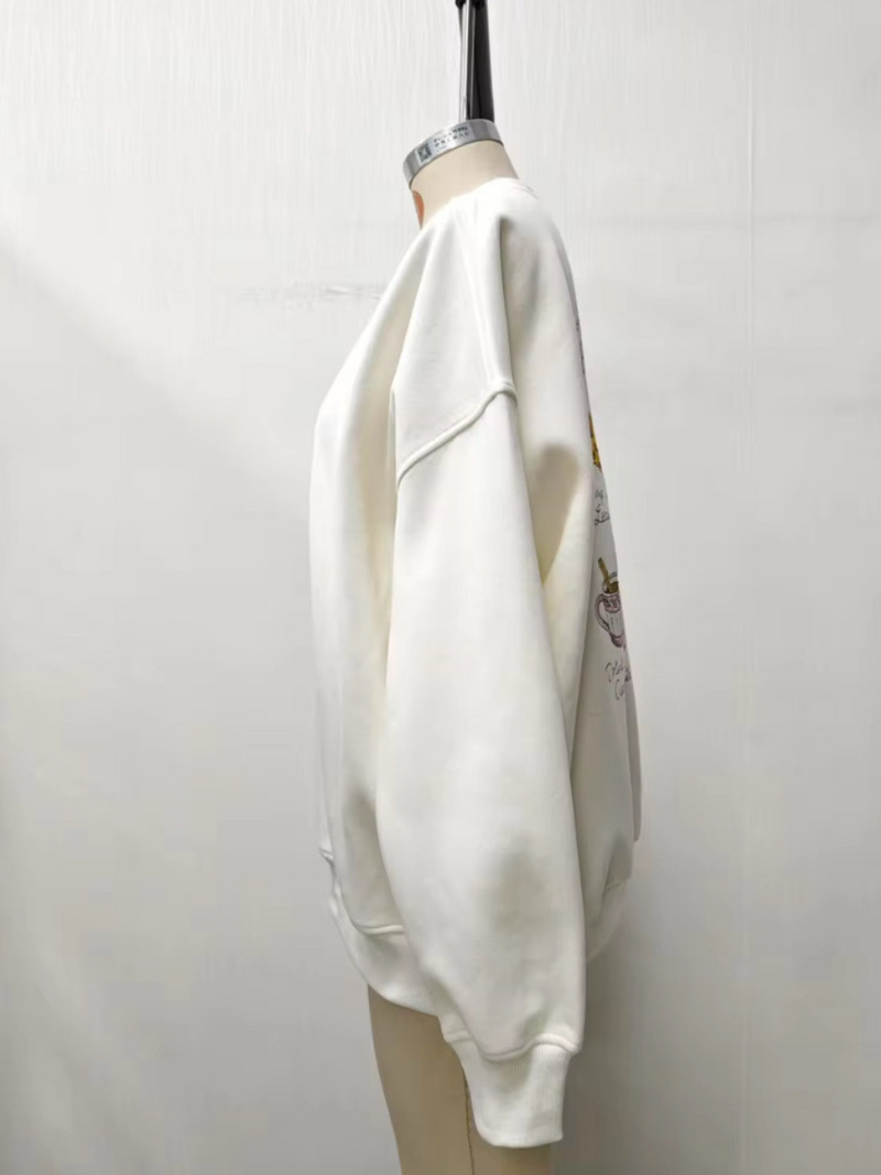 Cozy ivory sweatshirt featuring a whimsical embroidered autumn bucket list, perfect for relaxed Long Island boutique fashion.