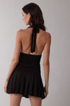 Black halter tie neck mini dress with a ruched bodice and flared skirt, perfect for a stylish summer look from this Long Island women's boutique.