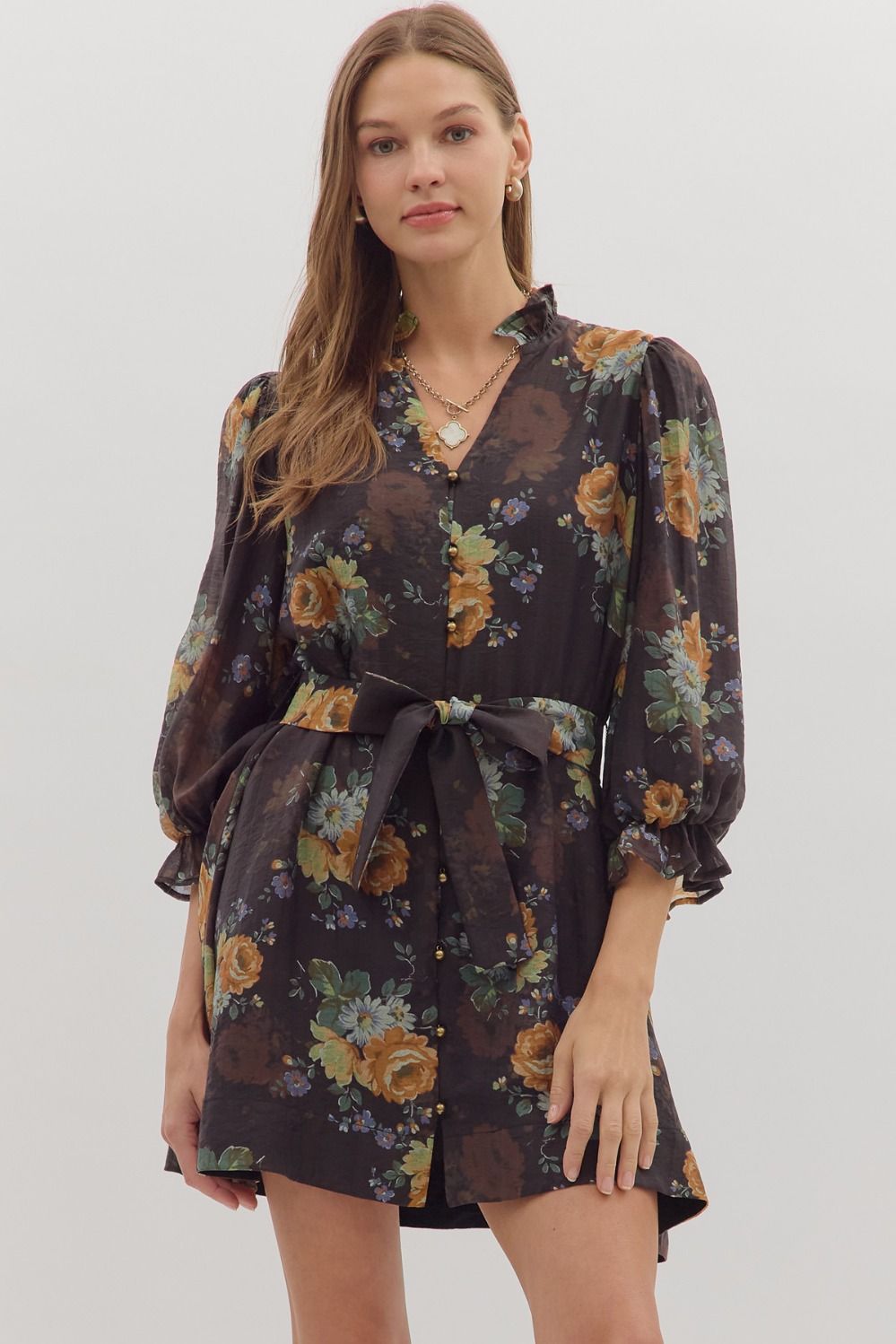 Floral print mini dress featuring 3/4 puff sleeves, a fitted waist with a bow tie, and a dark background, perfect for Long Island boutique fashion.