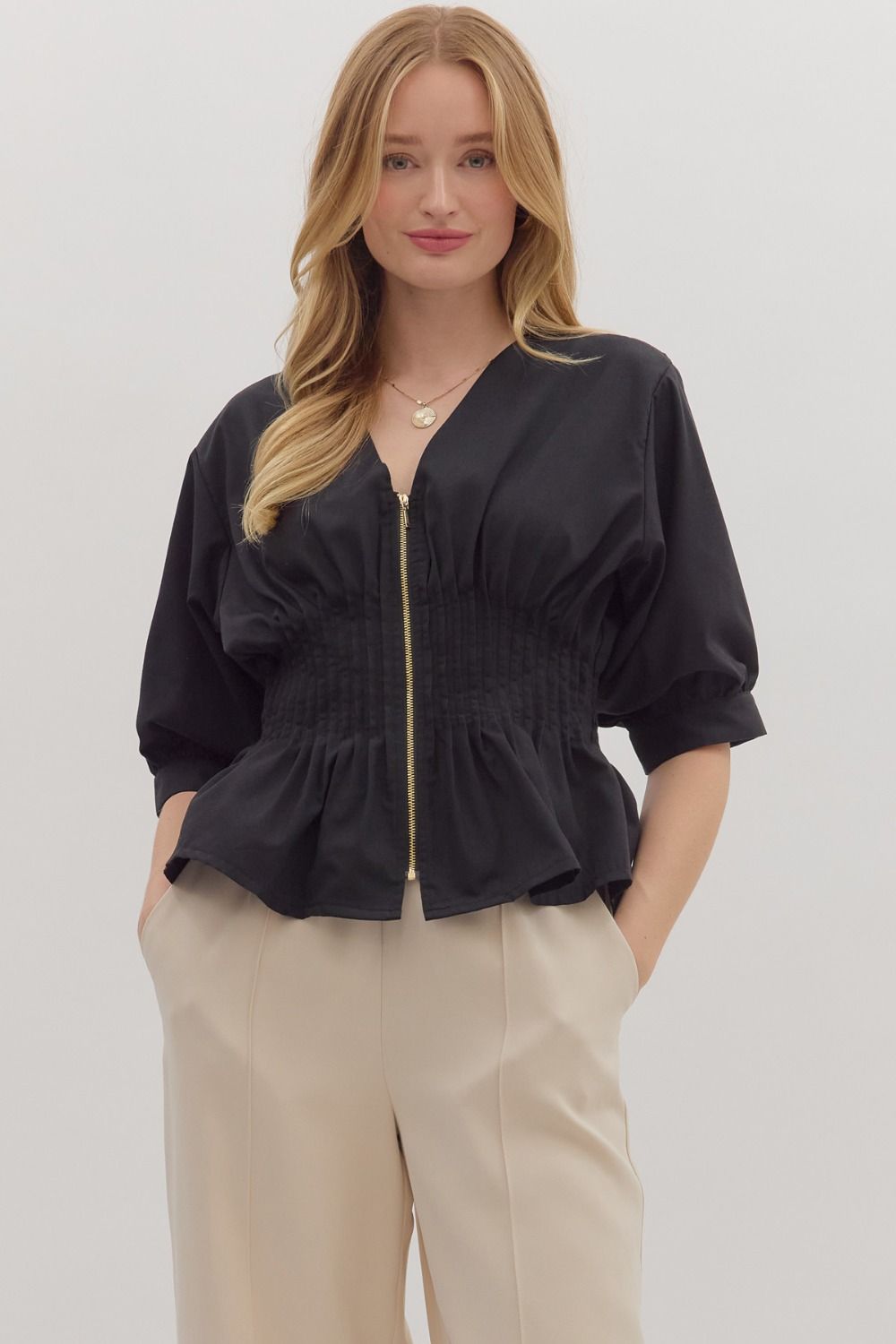 Elegant black 3/4 zip-up top featuring a flared hem and gathered details, perfect for stylish Long Island boutique fashion.