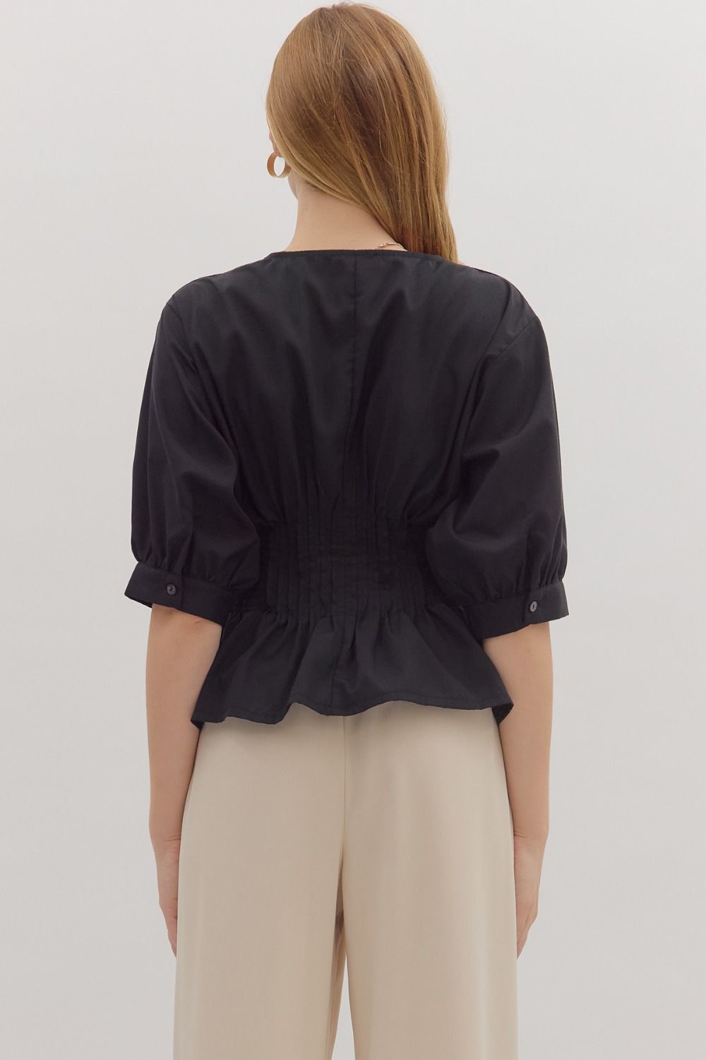 Elegant black 3/4 zip-up top featuring a flared hem and gathered details, perfect for stylish Long Island boutique fashion.