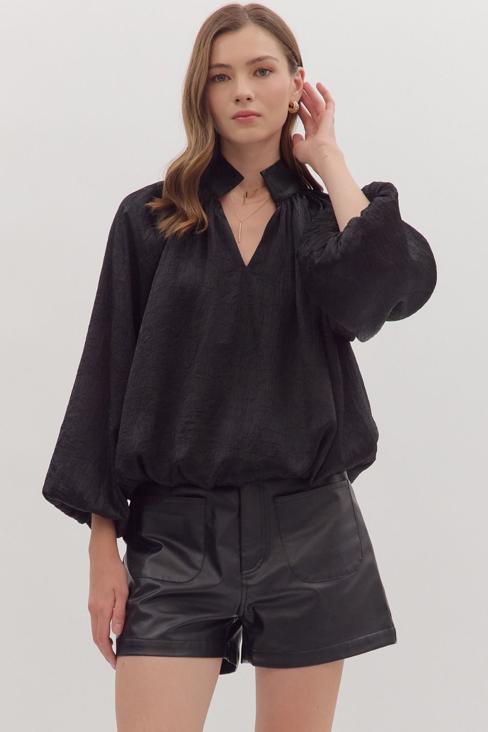 Chic black balloon sleeve V-neck top with a textured finish, perfect for trendy Long Island boutique fashion.