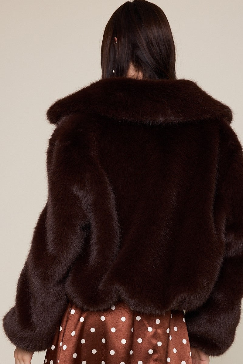 Cozy brown faux fur jacket with a wide collar and relaxed fit, perfect for adding a touch of luxury to any outfit in Long Island boutique fashion.