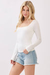 Double layer long sleeve top in soft white with a square neckline, paired with distressed denim shorts, showcasing Long Island boutique fashion.